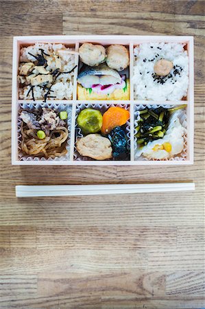 simsearch:6118-07808971,k - High angle close up of Bento box with traditional Japanese foods and chopsticks on a wooden table. Stock Photo - Premium Royalty-Free, Code: 6118-09079805