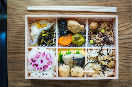 simsearch:6118-07808971,k - High angle close up of Bento box with traditional Japanese foods and chopsticks on a wooden table. Stock Photo - Premium Royalty-Free, Code: 6118-09079806