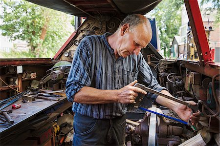 sawing - Blacksmith in his workshop on a working barge, at a work bench using a hacksaw. Stock Photo - Premium Royalty-Free, Code: 6118-09018506