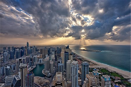 simsearch:649-07710299,k - Cityscape of the Dubai, United Arab Emirates under a cloudy sky, with skyscrapers and coastline of the Persian Gulf. Stock Photo - Premium Royalty-Free, Code: 6118-09028212