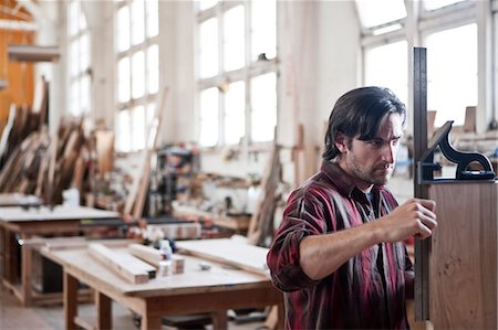 Caucasian man factory worker checking square measurements on a wooden part in a woodworking factory. Stock Photo - Premium Royalty-Free, Code: 6118-09140151