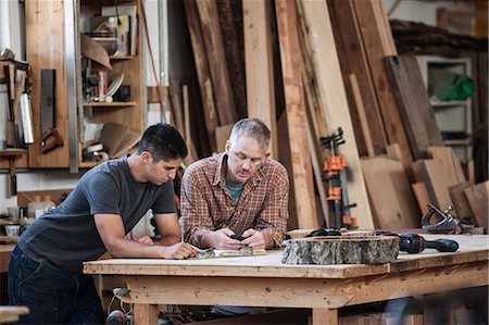 Team of two Caucasian men factory workers problem solving at a work station in a woodworking factory. Stock Photo - Premium Royalty-Free, Code: 6118-09140154