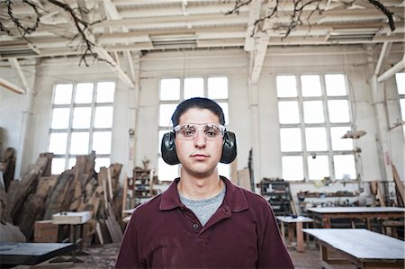 Caucasian man factory worker wearing hearing protection in a woodworking factory. Stock Photo - Premium Royalty-Free, Code: 6118-09140129
