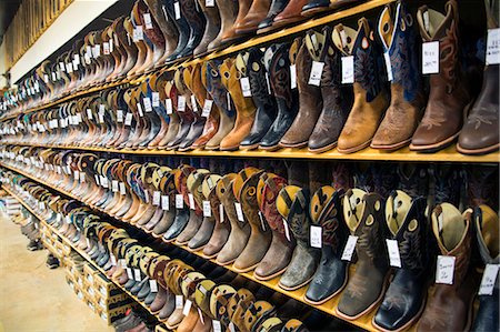 View of large selection of brown and black leather cowboy boots on shelves in a shoe shop. Stock Photo - Premium Royalty-Free, Code: 6118-09144803