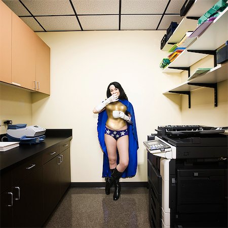 A Caucasian woman office super hero takes a break and has snack. Stock Photo - Premium Royalty-Free, Code: 6118-09147980