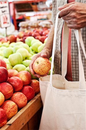 simsearch:614-06169178,k - Close up of person holding shopping bag and red apple at a fruit and vegetable market. Stock Photo - Premium Royalty-Free, Code: 6118-09148107