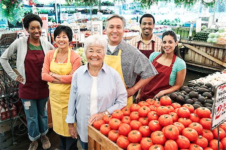 simsearch:614-06169178,k - High angle view of group of men and women wearing aprons standing at stall with fresh tomatoes at a fruit and vegetable market. Stock Photo - Premium Royalty-Free, Code: 6118-09148128