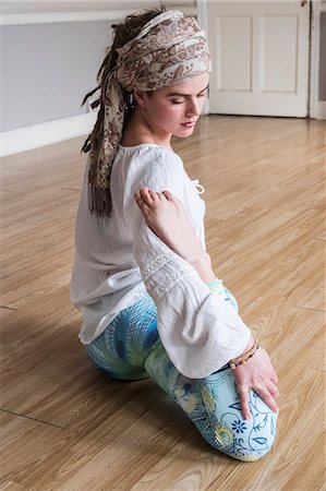 simsearch:400-04435419,k - Young woman wearing headscarf and white blouse sitting on floor in yoga pose. Stock Photo - Premium Royalty-Free, Code: 6118-09165852