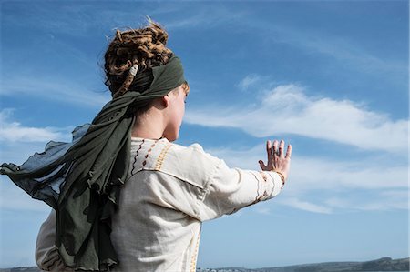 simsearch:6118-07731916,k - Young woman with brown hair and dreadlocks wearing headscarf standing on a beach , doing Tai Chi. Photographie de stock - Premium Libres de Droits, Code: 6118-09165834