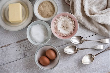 simsearch:6118-08521776,k - A table with ingredients for a baking project laid out, butter, sugar and flour, and two eggs. Stock Photo - Premium Royalty-Free, Code: 6118-09166070