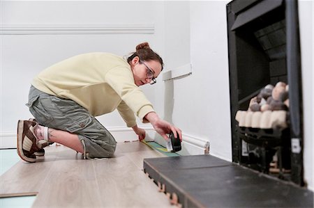 Woman measuring space fit new floor boards Stock Photo - Premium Royalty-Free, Code: 6118-09174337