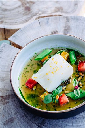 simsearch:6118-07808971,k - Pouring broth on halibut with lemon, peas, melon, beets and herbs Stock Photo - Premium Royalty-Free, Code: 6118-09174503