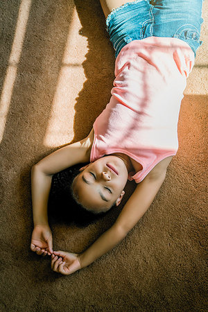 simsearch:614-06043612,k - Girl laying on living room carpet in the sunlight Stock Photo - Premium Royalty-Free, Code: 6118-09183224