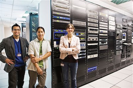 simsearch:6118-08660009,k - Portrait of three multi-ethnic technicians who work in a large computer server room. Stock Photo - Premium Royalty-Free, Code: 6118-09129379