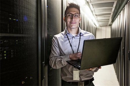 Hispanic man technician doing diagnostic tests on computer servers in a large server farm. Photographie de stock - Premium Libres de Droits, Code: 6118-09129838