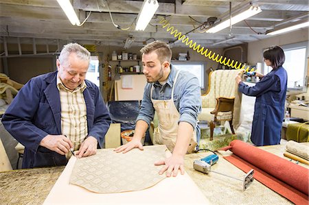 simsearch:6118-08660009,k - Young Caucasian man learning the art of upholstery from a senior male upholsterer. Stock Photo - Premium Royalty-Free, Code: 6118-09130087