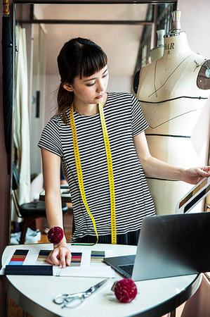 Japanese female fashion designer standing at desk, working in her studio. Photographie de stock - Premium Libres de Droits, Code: 6118-09200181