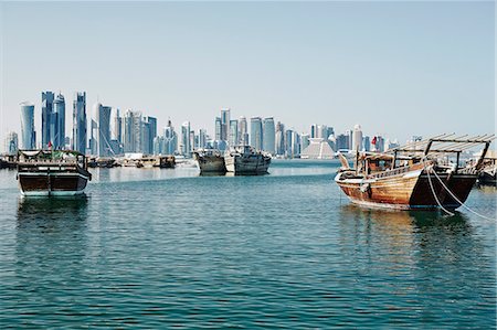 Downtown Doha with its impressive skyline of skyscrapers and authentic dhows in the bay, Doha, Qatar, Middle East Stock Photo - Premium Royalty-Free, Code: 6119-07652108