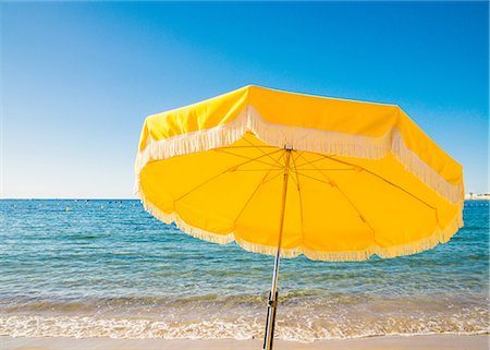 player - Giant yellow beach umbrella next to the ocean against a blue sky in Juan les Pins, Cote d'Azur, Provence, France, Mediterranean, Europe Foto de stock - Sin royalties Premium, Código: 6119-09054139