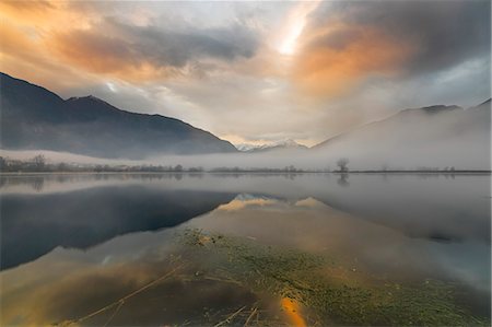Mountains reflected in water at dawn shrouded by mist, Pozzo di Riva Novate, Mezzola, Chiavenna Valley, Lombardy, Italy, Europe Stock Photo - Premium Royalty-Free, Code: 6119-09062009
