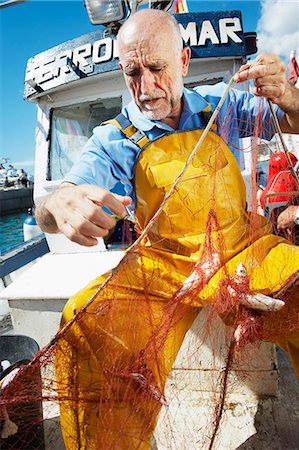 simsearch:400-05676936,k - Fisherman taking fish out of nets Stock Photo - Premium Royalty-Free, Code: 6122-07691683