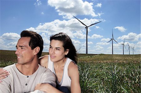 Young couple in a field by a wind farm Stock Photo - Premium Royalty-Free, Code: 6122-07693238