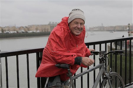 poncho - Man in raincoat with pushbike Stock Photo - Premium Royalty-Free, Code: 6122-07693635