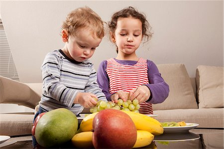 Boy and girl eating fruit Stock Photo - Premium Royalty-Free, Code: 6122-07693906