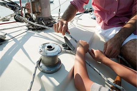 Father and son on board yacht with rope Stock Photo - Premium Royalty-Free, Code: 6122-07695045