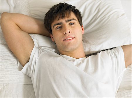 simsearch:649-07521015,k - Young man lying on bed with hands behind head, portrait Stock Photo - Premium Royalty-Free, Code: 6122-07696757