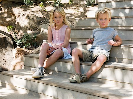 simsearch:6122-07698204,k - Brother and sister sitting on wooden steps, portrait Stock Photo - Premium Royalty-Free, Code: 6122-07697004