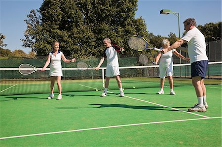 Senior and mature adults practising on tennis courts Stock Photo - Premium Royalty-Free, Code: 6122-07697843