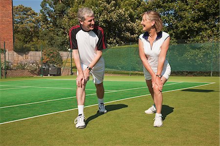 Mature woman and senior man performing warming up exercises on tennis court Stock Photo - Premium Royalty-Free, Code: 6122-07697850