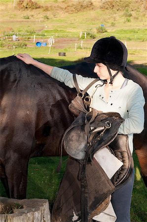 Young woman patting horses back Stock Photo - Premium Royalty-Free, Code: 6122-07698049