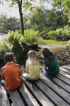simsearch:614-06043612,k - Three children sitting on boardwalk in forest Stock Photo - Premium Royalty-Free, Code: 6122-07698099