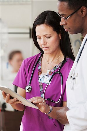 Doctors and nurse in discussion over patients records in hospital Stock Photo - Premium Royalty-Free, Code: 6122-07698302