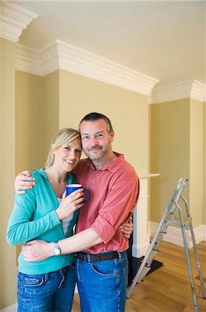 simsearch:6122-07704462,k - Smiling couple hugging in new home Stock Photo - Premium Royalty-Free, Code: 6122-07698968