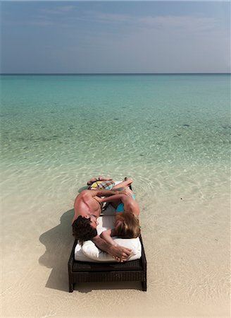 simsearch:6122-07699140,k - Couple relaxing on daybed at beach Foto de stock - Sin royalties Premium, Código: 6122-07699044