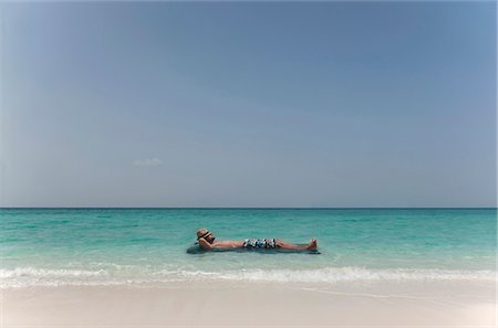 Man floating in water at tropical beach Stock Photo - Premium Royalty-Free, Code: 6122-07699037