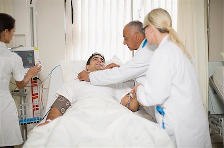 simsearch:6113-07905850,k - Doctors and nurse tending to patient Stock Photo - Premium Royalty-Free, Code: 6122-07699193