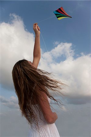 sky in kite alone pic - Woman flying a kite Stock Photo - Premium Royalty-Free, Code: 6122-07699108