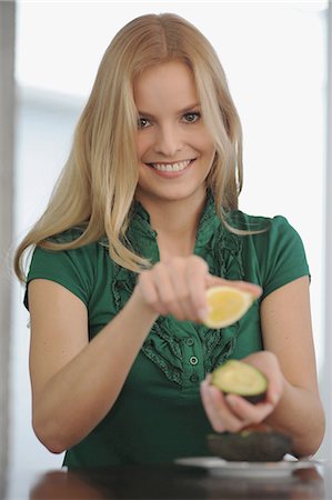 single lemon - Smiling woman eating at table Stock Photo - Premium Royalty-Free, Code: 6122-07699722