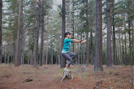 simsearch:6122-08212737,k - Woman balancing on stump in forest Stock Photo - Premium Royalty-Free, Code: 6122-07700488