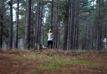 Woman running in forest Stock Photo - Premium Royalty-Free, Code: 6122-07700497