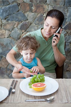 Woman eating breakfast with son Stock Photo - Premium Royalty-Free, Code: 6122-07701100