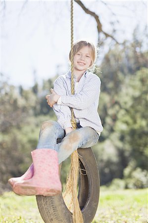 Girl sitting on tire swing outdoors Stock Photo - Premium Royalty-Free, Code: 6122-07701669