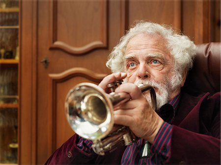 playing music - Older man playing trumpet indoors Stock Photo - Premium Royalty-Free, Code: 6122-07702054