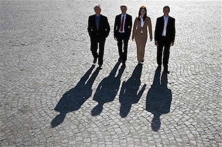 people in a row - Business people walking on cobbled road Stock Photo - Premium Royalty-Free, Code: 6122-07702059