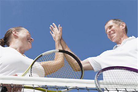 Older couple high fiving during tennis Stock Photo - Premium Royalty-Free, Code: 6122-07702114
