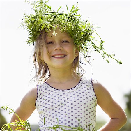 Smiling girl wearing grassy crown Stock Photo - Premium Royalty-Free, Code: 6122-07702299